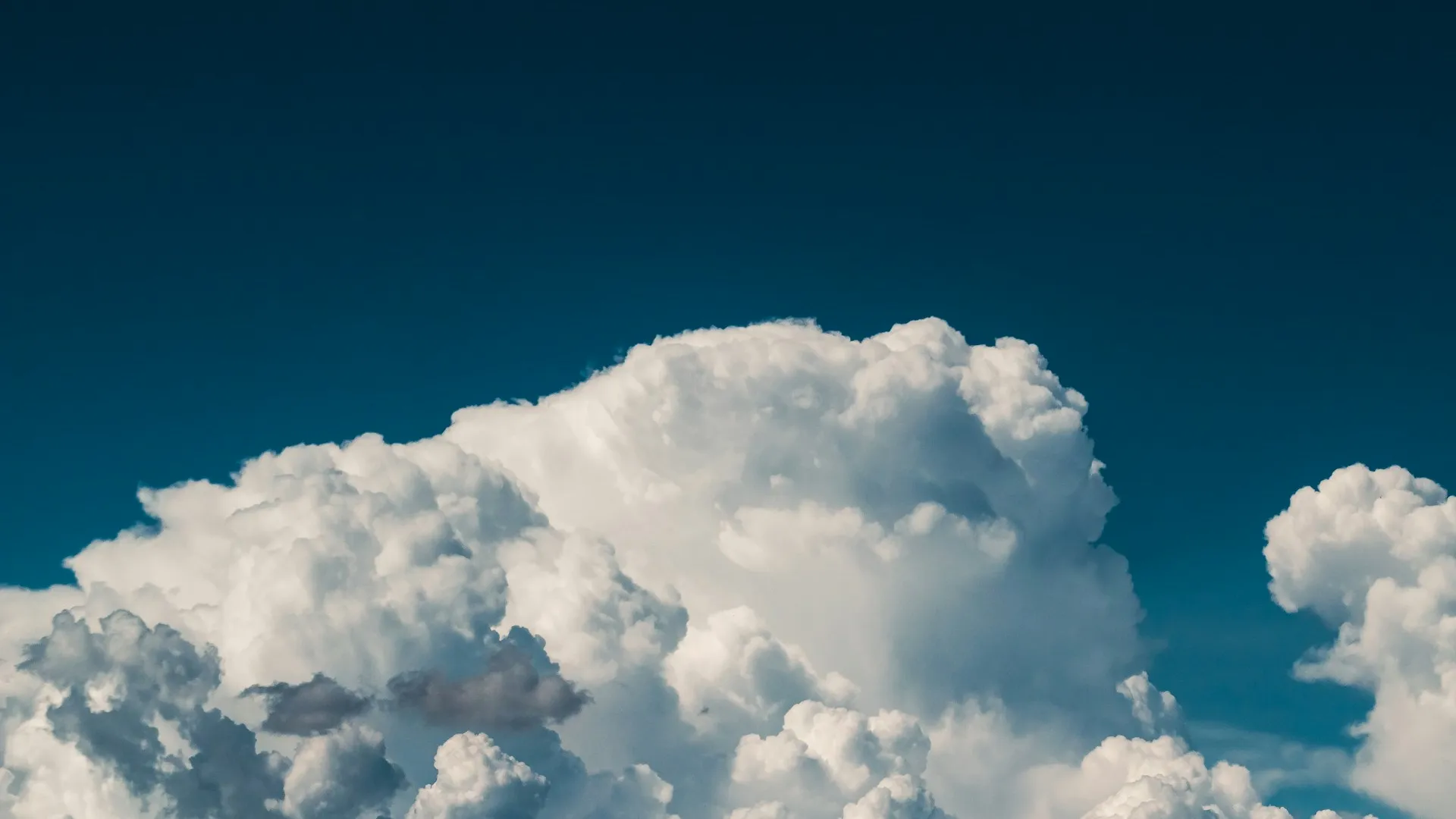 A huge, white cloud on a dark azure sky.