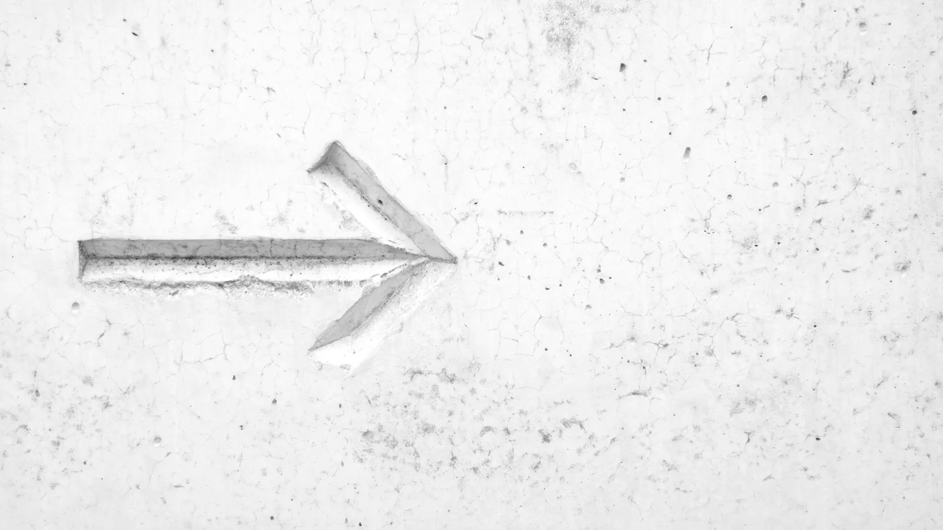 A forward arrow etched in a wall.